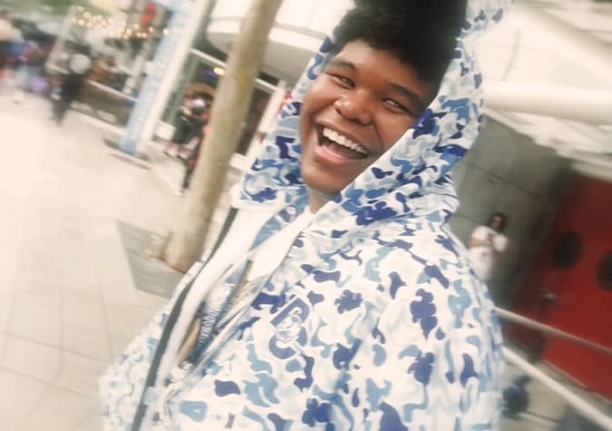 Jacob Fernandez laughing, wearing a blue camo hoodie
